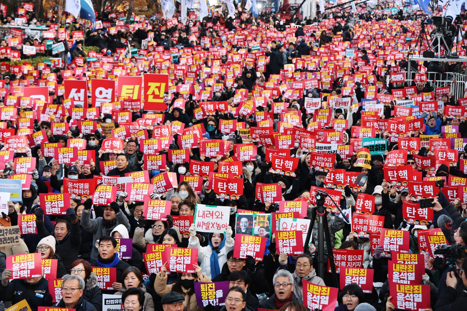 epa11761580 Protesters hold placards calling for the impeachment of President Yoon Suk Yeol in front of the National Assembly in Seoul, South Korea, 07 December 2024. Yoon apologised to the nation in a short televised address ahead of a vote on his impeachment in the National Assembly on 07 December. He faces an impeachment motion from opposition lawmakers after he declared and then reversed martial law, citing the need to root out pro-North Korean forces and uphold the constitutional order.  EPA/HAN MYUNG-GU