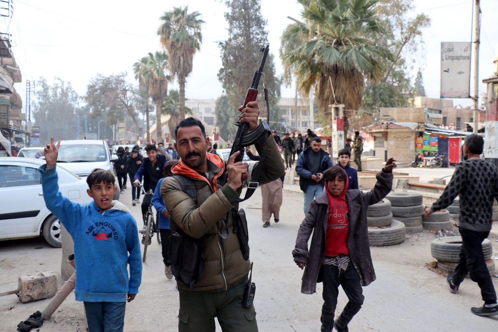 epa11764678 A fighter of the Syrian Democratic Forces (SDF) celebrates with residents after the SDF took control of the city of al-Hasakah, northeast Syria, 08 December 2024. SDF Commander-in-Chief Mazloum Abdi said in a statement on 08 December that 'Syria is living historic moments as we witness the fall of the oppressive regime in Damascus'. Syrian rebels led by Hayat Tahrir al-Sham (HTS) entered Damascus on 08 December 2024 and announced in a televised statement the 'Liberation of the city of Damascus and the overthrow of Bashar al-Assad', as well as the release of all the prisoners.  EPA/AHMED MARDNLI