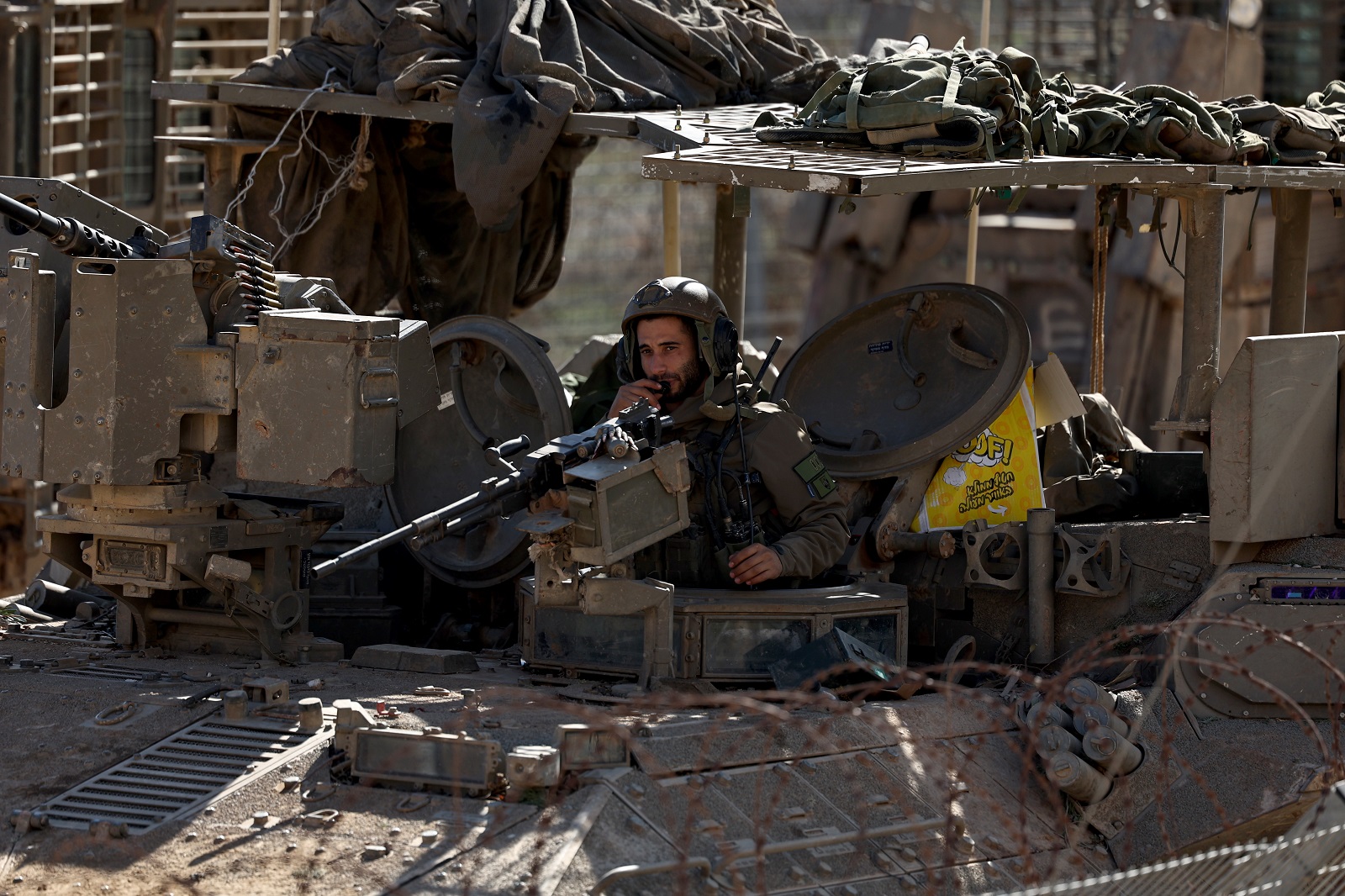 epa11774260 An Israeli soldier aboard an armoured vehicle mans a machine gun as they cross into the buffer zone between Israel and Syria, near the Druze village of Majdal Shams, in the Israeli-annexed Golan Heights, 13 December 2024. Israel's military said that paratroopers' forces, joined by other troops, are conducting 'defense activities' to prevent 'any threat' and are deployed in key positions within the buffer zone.  EPA/ATEF SAFADI