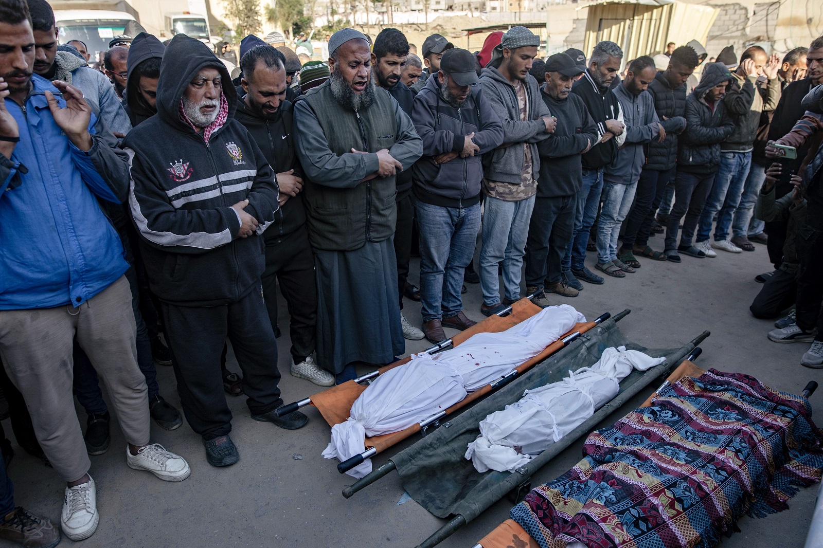 epa11780163 Palestinians pray in front of bodies of their relatives, after an Israeli air strike hit a UNRWA-run school, housing displaced people, in Khan Younis, southern Gaza Strip, 16 December 2024. According to medics at Nasser Hospital, at least 15 Palestinians were killed in the Israeli airstrike. More than 45,000 Palestinians and over 1,400 Israelis have been killed, according to the Palestinian Health Ministry and the Israeli Army, since Hamas militants launched an attack against Israel from the Gaza Strip on 07 October 2023, and the Israeli operations in Gaza and the West Bank which followed it.  EPA/HAITHAM IMAD