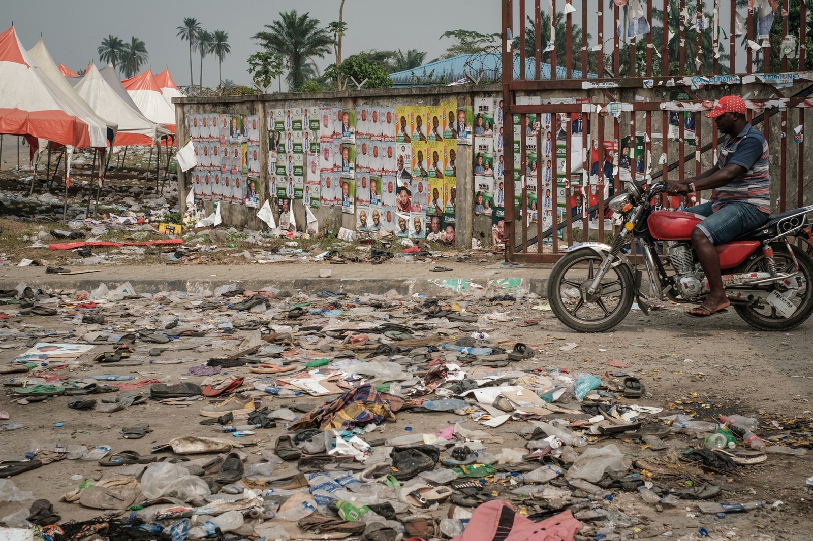 A biker rides next to shoes and items lying on the ground on February 13, 2019 in front of the main entrance of the Adokiye Amiesimaka Stadium where fifteen people were killed on February 12, 2019 in a stampede during an election campaign rally held by Nigerian President in Port Harcourt, Southern Nigeria. The deaths are the latest on the campaign trail before February 16 election, at which Buhari is seeking a second, four-year term of office.,Image: 413714786, License: Rights-managed, Restrictions: , Model Release: no, Credit line: Yasuyoshi CHIBA / AFP / Profimedia