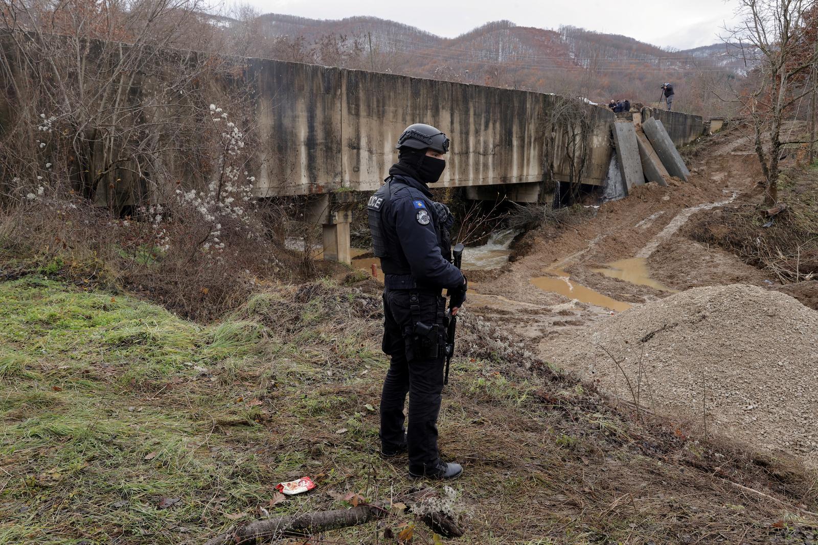 A Kosovo police officer patrols near the damaged canal supplying water to two coal-fired power plants that generate nearly all of the country's electricity, in Varage, near Zubin Potok, Kosovo December 1, 2024. REUTERS/Valdrin Xhemaj Photo: Valdrin Xhemaj/REUTERS