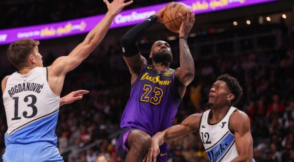 Dec 6, 2024; Atlanta, Georgia, USA; Los Angeles Lakers forward LeBron James (23) shoots past Atlanta Hawks guard Bogdan Bogdanovic (13) and forward De'Andre Hunter (12) in the second quarter at State Farm Arena. Mandatory Credit: Brett Davis-Imagn Images Photo: Brett Davis/REUTERS