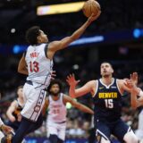 Dec 7, 2024; Washington, District of Columbia, USA; Washington Wizards guard Jordan Poole (13) shoots the ball as Denver Nuggets center Nikola Jokic (15) looks on in the third quarter at Capital One Arena. Mandatory Credit: Geoff Burke-Imagn Images Photo: Geoff Burke/REUTERS