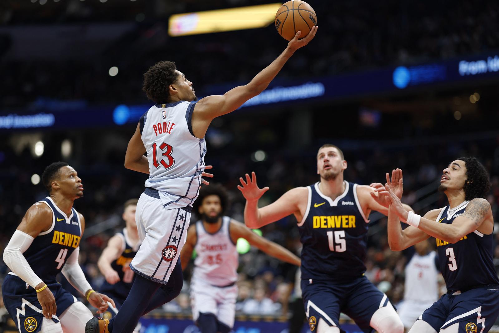 Dec 7, 2024; Washington, District of Columbia, USA; Washington Wizards guard Jordan Poole (13) shoots the ball as Denver Nuggets center Nikola Jokic (15) looks on in the third quarter at Capital One Arena. Mandatory Credit: Geoff Burke-Imagn Images Photo: Geoff Burke/REUTERS