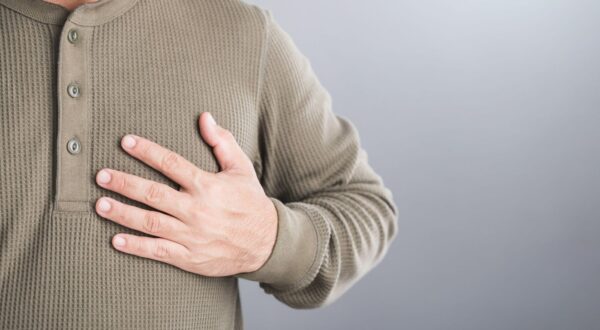 A man touches his left chest, indicating pain that may signal heart or cardiovascular issues. Image emphasizes the importance of early detection and awareness in preventing heart-related health risks,Image: 942058392, License: Royalty-free, Restrictions: , Model Release: no, Credit line: Phanuwat Nandee / Alamy / Alamy / Profimedia