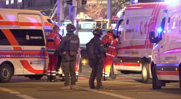 Police and ambulances stand next to the Christmas market, where a car crashed into a crowd injuring between 