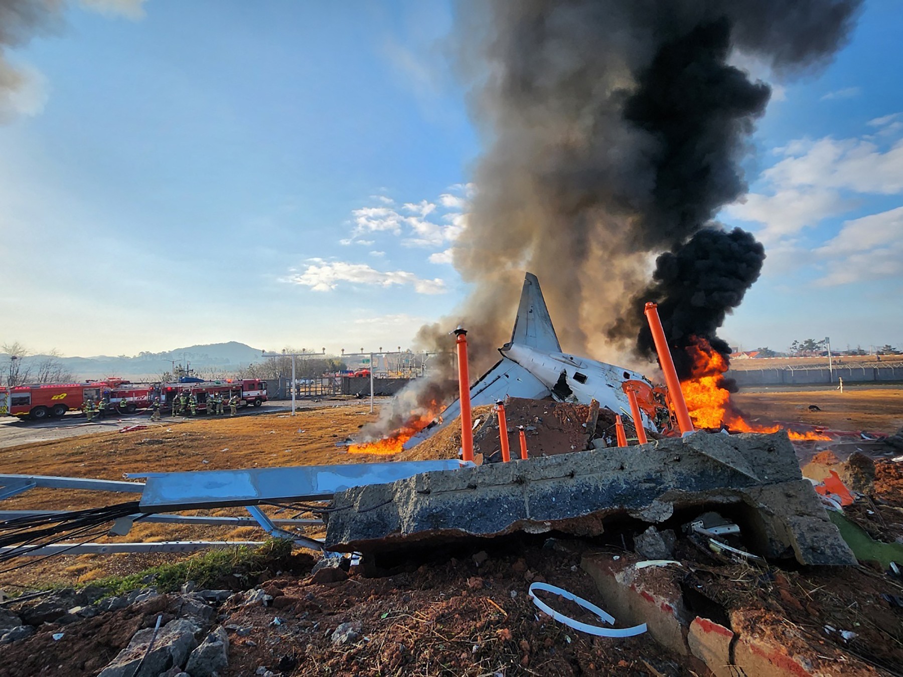 fire and smoke rise from the tail section of a Jeju Air Boeing 737-800 series aircraft after the plane crashed and burst into flames at Muan International Airport in South Jeolla Province, some 288 kilometres southwest of Seoul on December 29, 2024. A Jeju Air plane carrying 181 people from Bangkok to South Korea crashed on arrival on December 29, authorities told AFP, with 29 confirmed dead and dramatic video showing the aircraft bursting into flames.,Image: 950658349, License: Rights-managed, Restrictions: - South Korea OUT / NO ARCHIVES -  RESTRICTED TO SUBSCRIPTION USE, Model Release: no, Credit line: AFP / AFP / Profimedia