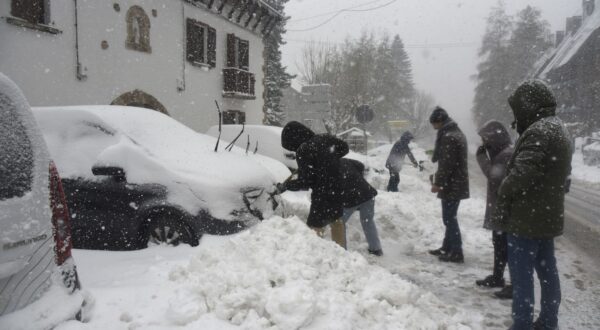 epa11764613 People walk during a snowfall in Canfranc, Huesca, Spain, 08 December 2024.  EPA/JAVIER BLASCO