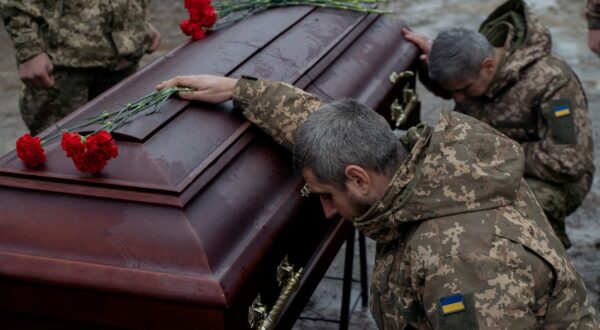 Ukrainian army members mourn next to the coffin of Pavlo Vedybida, callsign 