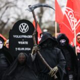 epa11732366 A protestor carries a tombstone for German automobile manufacturer Volkswagen during a protest supporting a third round of wage negotiations between IG Metall and Volkswagen AG, in Wolfsburg, Germany, 21 November 2024. Germany's largest carmaker Volkswagen may close three factories dedicated to its core brand in Germany and reduce employee wages, according to the company's workers council. This announcement sets the stage for a potentially prolonged dispute with unions representing around 120,000 German workers.  EPA/FILIP SINGER