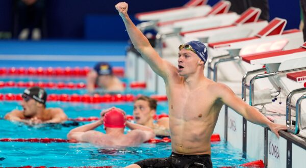 Leon Marchand, of France, celebrates after winning the men's 400-meter individual medley final at the 2024 Summer Olympics, Sunday, July 28, 2024, in Nanterre, France.(AP Photo/Martin Meissner) APTOPIX Paris Olympics Swimming