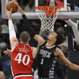 San Antonio Spurs' Victor Wembanyama (1) blocks a shot by Los Angeles Clippers' Ivica Zubac during the first half of an NBA basketball game, Tuesday, Dec. 31, 2024, in San Antonio. (AP Photo/Darren Abate)