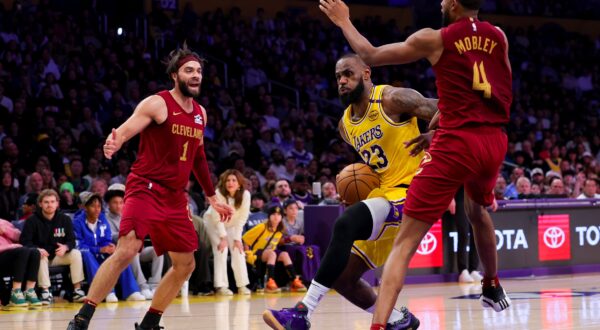 Los Angeles Lakers forward LeBron James, center, drives against Cleveland Cavaliers guard Max Strus, left, and forward Evan Mobley during the second half of an NBA basketball game Tuesday, Dec. 31, 2024, in Los Angeles. (AP Photo/Ryan Sun) Cavaliers Lakers Basketball