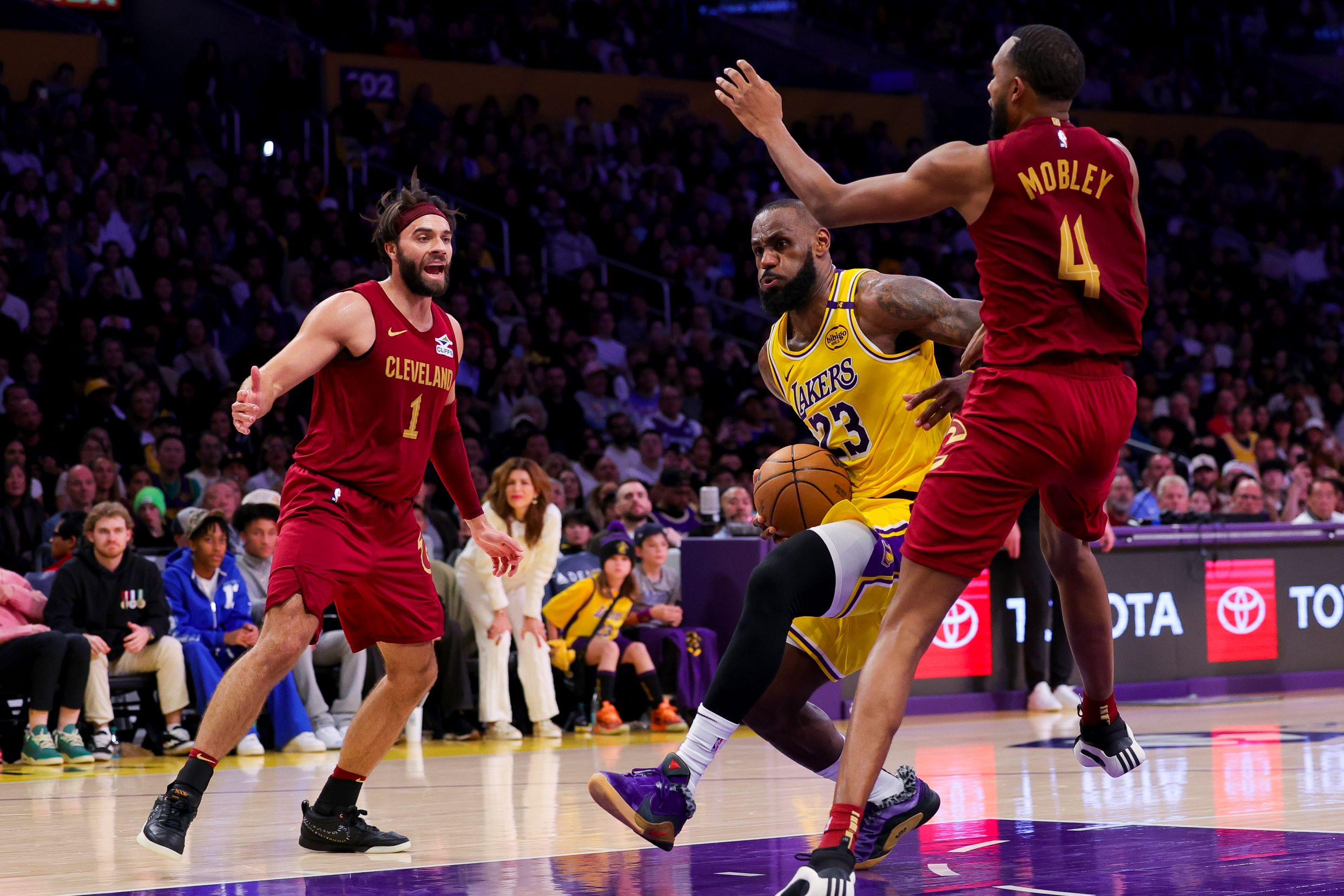 Los Angeles Lakers forward LeBron James, center, drives against Cleveland Cavaliers guard Max Strus, left, and forward Evan Mobley during the second half of an NBA basketball game Tuesday, Dec. 31, 2024, in Los Angeles. (AP Photo/Ryan Sun) Cavaliers Lakers Basketball