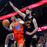 Oklahoma City Thunder guard Aaron Wiggins (21) goes to the basket against Cleveland Cavaliers forward Dean Wade (32) during the first half of an NBA basketball game Thursday, Jan. 16, 2025, in Oklahoma City. (AP Photo/Nate Billings) Cavaliers Thunder Basketball