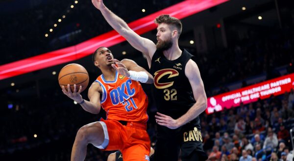 Oklahoma City Thunder guard Aaron Wiggins (21) goes to the basket against Cleveland Cavaliers forward Dean Wade (32) during the first half of an NBA basketball game Thursday, Jan. 16, 2025, in Oklahoma City. (AP Photo/Nate Billings) Cavaliers Thunder Basketball