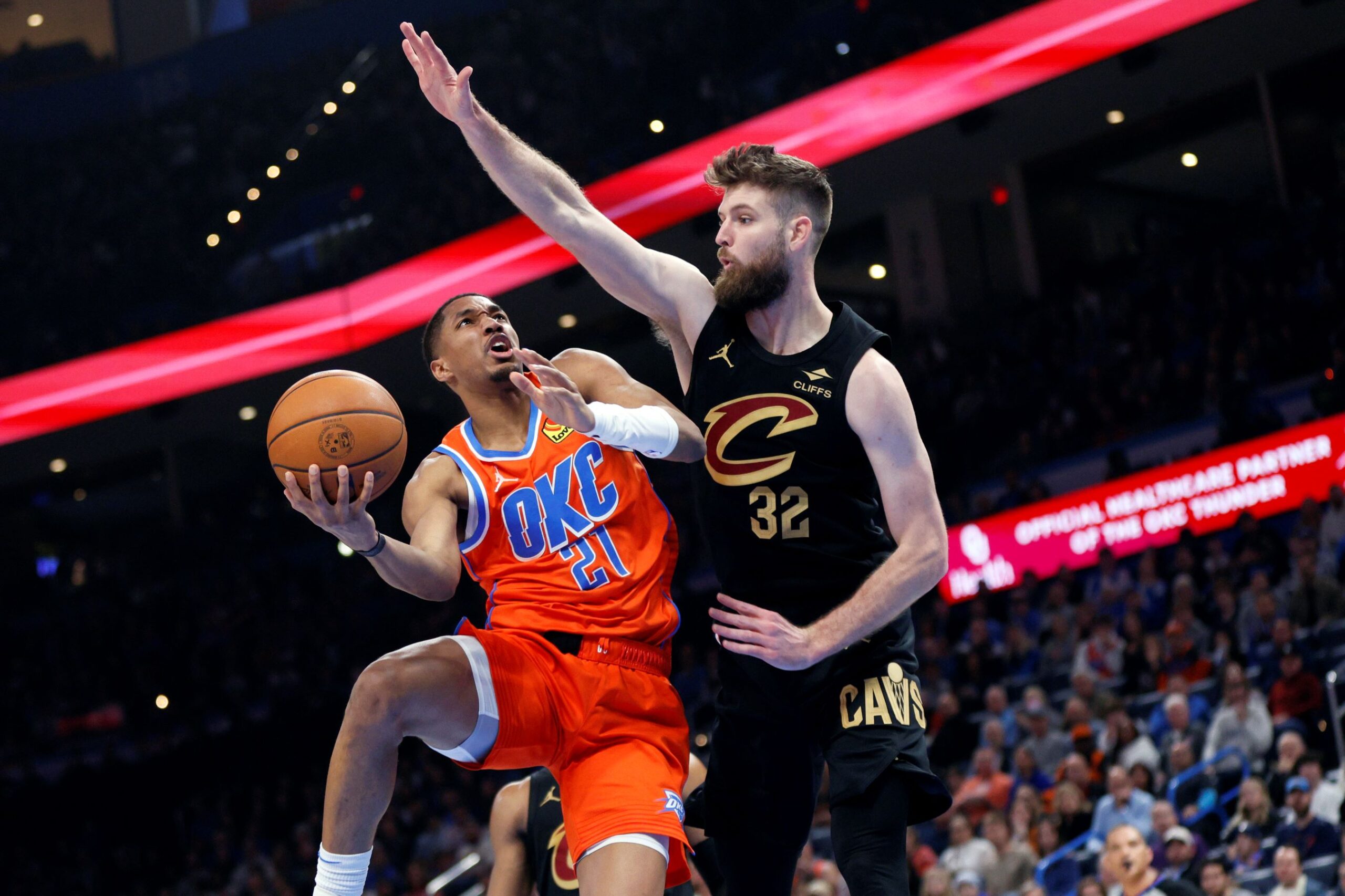 Oklahoma City Thunder guard Aaron Wiggins (21) goes to the basket against Cleveland Cavaliers forward Dean Wade (32) during the first half of an NBA basketball game Thursday, Jan. 16, 2025, in Oklahoma City. (AP Photo/Nate Billings) Cavaliers Thunder Basketball