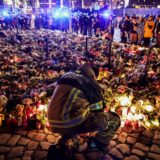 epa11791323 A firefighter in front of candles and flowers at the mourning site in front of St. John's Church following a vehicle-ramming attack on the Christmas market in Magdeburg, Germany, 23 December 2024. According to Saxony-Anhalt State Premier Haseloff, five people were confirmed dead and at least 235 were injured after a car was driven into a crowd at Magdeburg's Christmas market on 20 December. The suspect, a Saudi national, was taken into custody.  EPA/FILIP SINGER