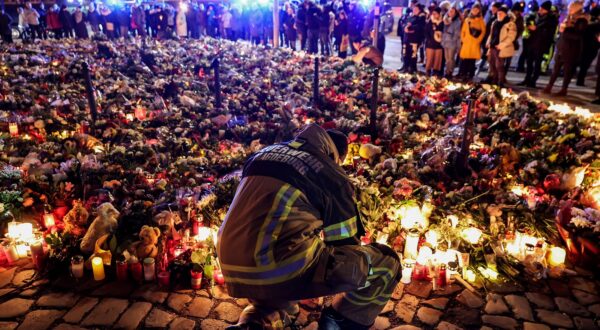 epa11791323 A firefighter in front of candles and flowers at the mourning site in front of St. John's Church following a vehicle-ramming attack on the Christmas market in Magdeburg, Germany, 23 December 2024. According to Saxony-Anhalt State Premier Haseloff, five people were confirmed dead and at least 235 were injured after a car was driven into a crowd at Magdeburg's Christmas market on 20 December. The suspect, a Saudi national, was taken into custody.  EPA/FILIP SINGER