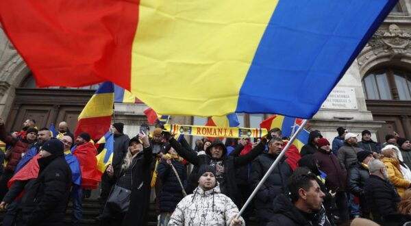 epa11799300 Supporters of independent candidate Calin Georgescu (not pictured) wave Romanian national flags as they gather on the steps of the Bucharest Court of Appeal headquarters in Bucharest, Romania, 30 December 2024. Georgescu, winner of the first round of the annulled presidential elections, filed a lawsuit challenging the Central Electoral Bureau's annulment of the entire electoral process and the resumption of the presidential elections, based on the Romanian Constitutional Court's ruling, and pressed charges against several prominent political figures and institutions in Romania.  EPA/BOGDAN CRISTEL