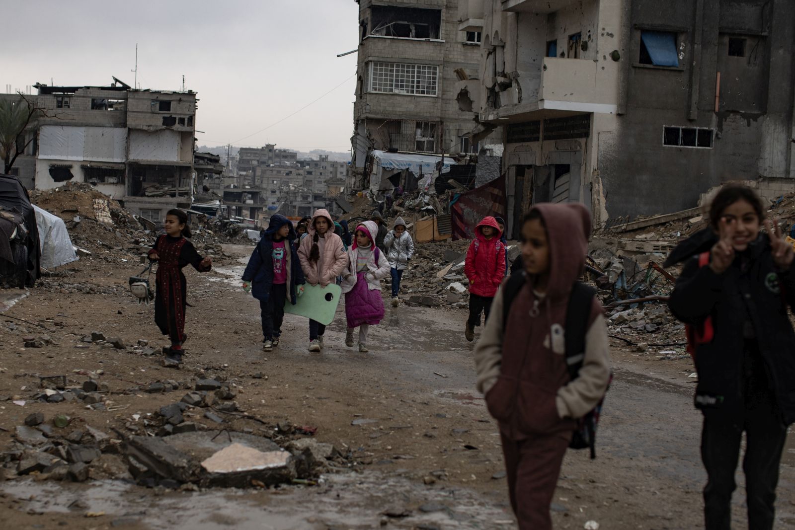 epa11799809 Palestinian children walk past their destroyed homes during heavy rains in Khan Yunis camp in the southern Gaza Strip, 31 December, 2024. According to the UN, at least 1.9 million people (or nine in ten people) across the Gaza Strip are internally displaced, including people who have been repeatedly displaced. Since October 2023, only about 11 percent of the Gaza Strip has not been placed under Israeli-issued evacuation orders, the UN aid coordination office OCHA said.   EPA/HAITHAM IMAD