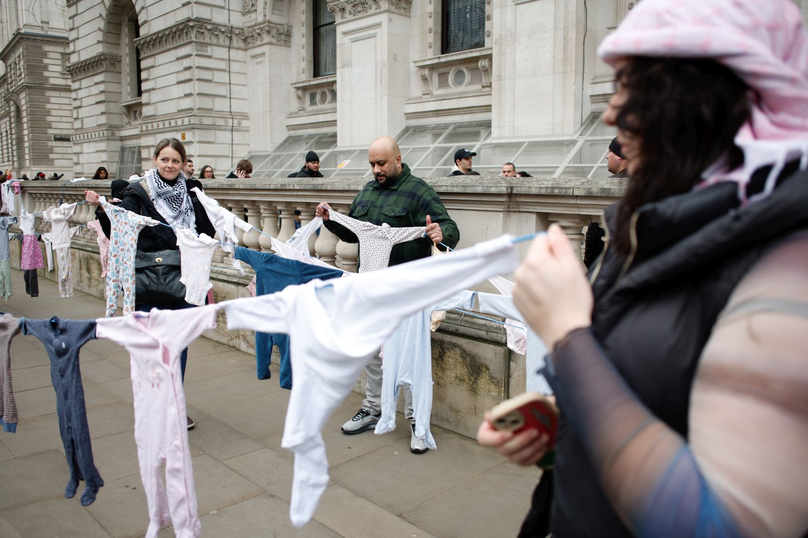 epa11833869 Pro-Palestinian activists holding children's clothes representing children killed in the war in Gaza while demonstrating on Whitehall in London, Britain, 18 January 2025. Protesters demand the end of Israeli operations in the Gaza Strip and for the British government to end to all arms trade with Israel. A plan for a protest march was changed by the Metropolitan Police through their powers under the Public Order Act as it was due to pass a synagogue in central London.  EPA/DAVID CLIFF