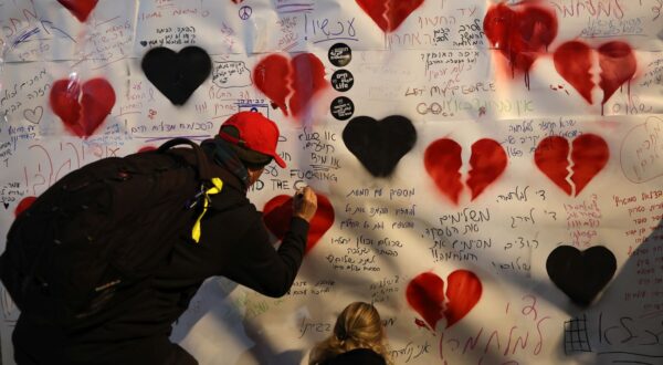 epa11834856 People write messages on a poster as families of people who were abducted during the 2023 Hamas attack in Israel rally in Tel Aviv, Israel, 18 January 2025. A ceasefire between Israel and Hamas will take effect on 19 January 2025. More than 46.000 people have been killed in Gaza since October 2023, when Israel launched a military campaign in response to a cross-border attack by Hamas, in which about 1,200 people were killed and over 200 taken hostage.  EPA/ATEF SAFADI