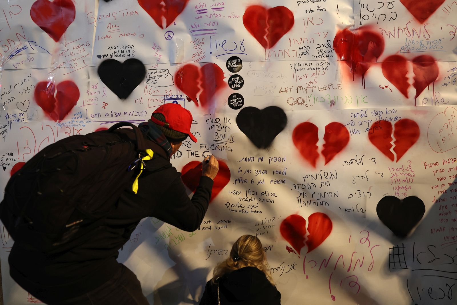 epa11834856 People write messages on a poster as families of people who were abducted during the 2023 Hamas attack in Israel rally in Tel Aviv, Israel, 18 January 2025. A ceasefire between Israel and Hamas will take effect on 19 January 2025. More than 46.000 people have been killed in Gaza since October 2023, when Israel launched a military campaign in response to a cross-border attack by Hamas, in which about 1,200 people were killed and over 200 taken hostage.  EPA/ATEF SAFADI