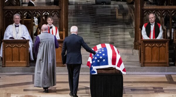 epa11815323 US President Joe Biden (C) touches the flag-draped casket of former US President Jimmy Carter before delivering remarks during Carter's State Funeral services at the National Cathedral in Washington, DC, USA, 09 January 2025. Carter, the 39th US president, died at age 100 in his hometown of Plains, Georgia, on 29 December 2024.  EPA/HAIYUN JIANG/ POOL