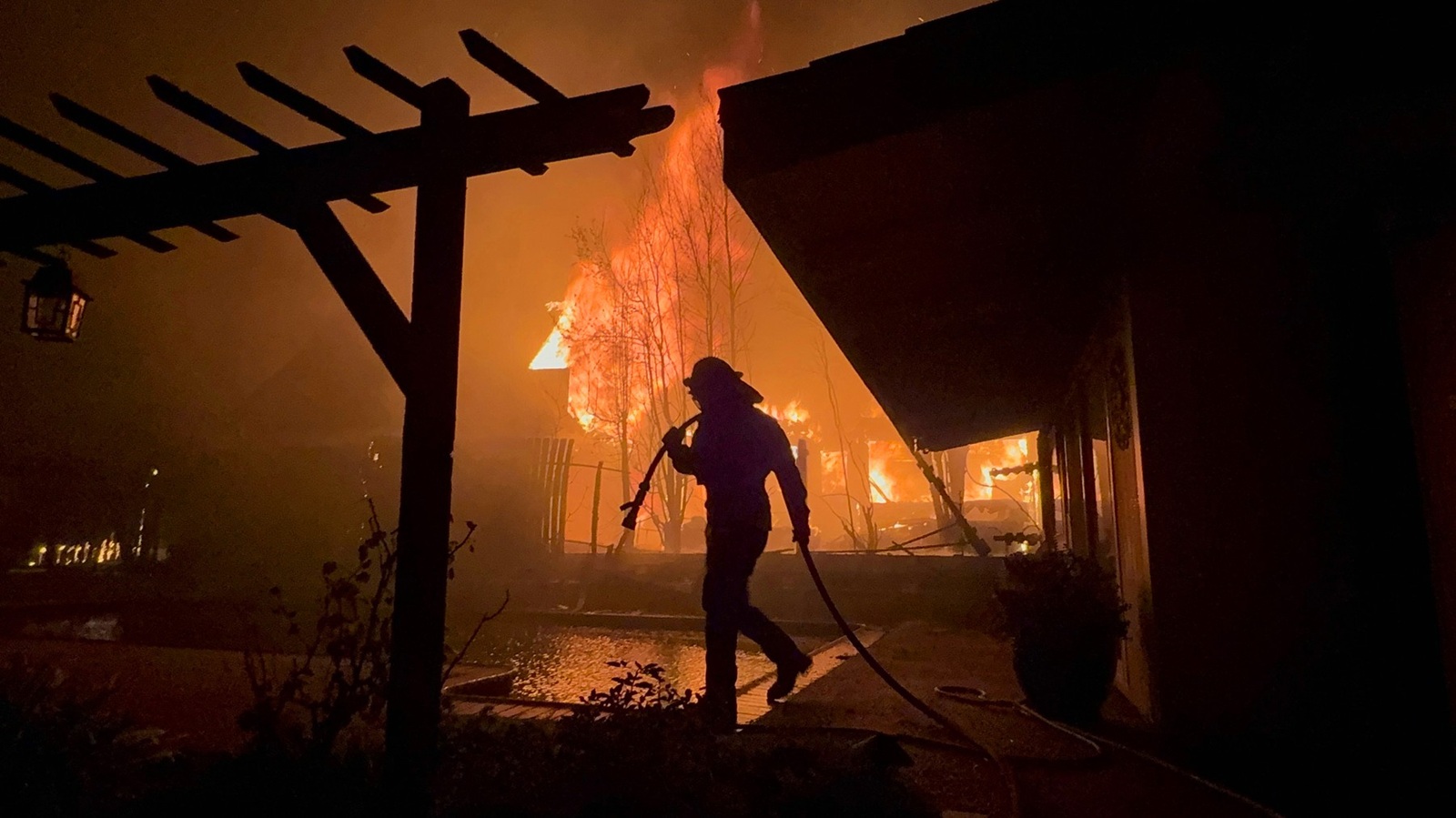 January 8, 2025, Altadena, California, USA: A Firefighter works to save a home during the Eaton fire outside of Los Angeles. Evacuation orders are in place after a fast moving brush fire broke out Tuesday night. Four fires are currently burning, Palisades, Eaton, Hurst and Woodley, all are 0% contained with two people killed and more than 1,000 structures burnt. Palisades has now become the most destructive in LA's history. Tens of thousands of people have been forced to evacuate their homes.,Image: 952438193, License: Rights-managed, Restrictions: , Model Release: no, Credit line: Andrew Silk / Zuma Press / Profimedia