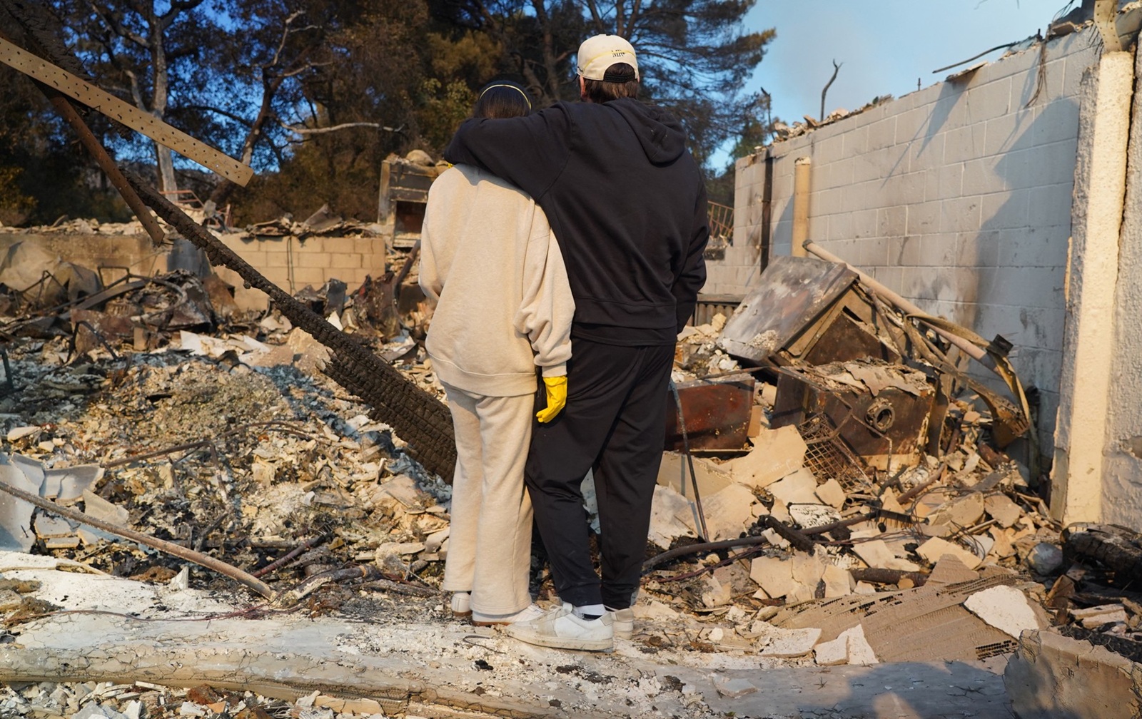 Kyle Kucharski hugs his partner Nicole Perri as they stand on the ruins of their house destroyed by the Palisades Fire in the Pacific Palisades neighborhood of Los Angeles, California on January 10, 2025.  When Kyle Kucharski and Nicole Perri moved into their dream home in the Pacific Palisades area of Los Angeles, they bought a crate of wine to mark the realization of a dream, and put it aside for a special day.
That day never came. 
Now after a raging fire destroyed almost the entire neighborhood, all they have left is the empty box with the brand name written across it: Purgatory.,Image: 952856518, License: Rights-managed, Restrictions: To go with AFP story by Paula RAMON: "'Purgatory: Los Angeles fire leaves nothing but a tiny memento", Model Release: no, Credit line: Cecilia SANCHEZ / AFP / Profimedia