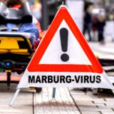 Germany - October 3, 2024: Warning sign: Marburg virus, in front of emergency paramedics on a street. Symbolic image of the dangerous virus spreading and infecting others. PHOTOMONTAGE *** Warnschild: Marburg-Virus, vor Notfallsanitätern auf einer Straße. Symbolbild Notfall und Ansteckung des gefährlichen Virus. FOTOMONTAGE,Image: 915611711, License: Rights-managed, Restrictions: imago is entitled to issue a simple usage license at the time of provision. Personality and trademark rights as well as copyright laws regarding art-works shown must be observed. Commercial use at your own risk., Model Release: no, Credit line: Michael Bihlmayer / imago stock&people / Profimedia