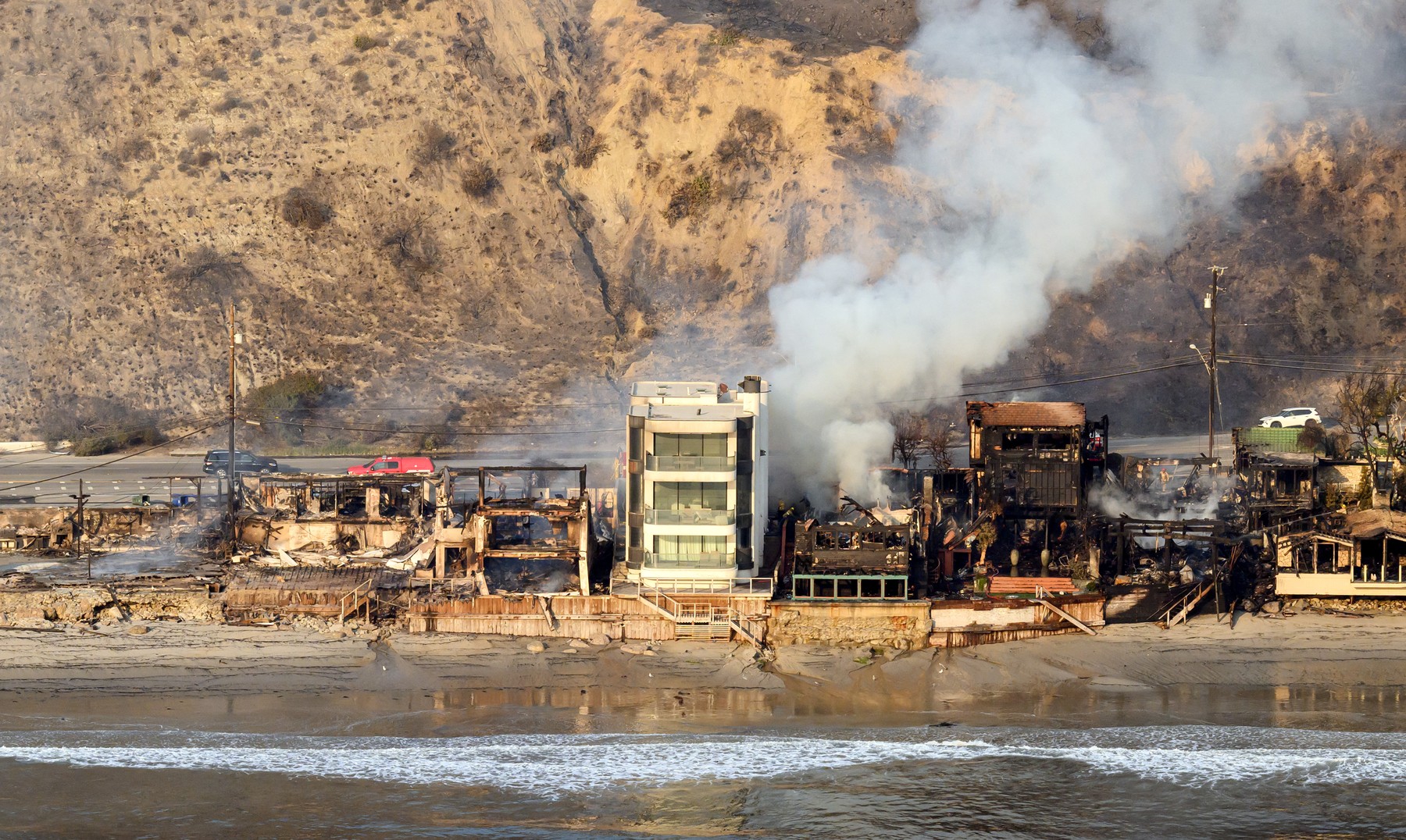 In this aerial view taken from a helicopter, burned homes are seen from above during the Palisades fire in Malibu, Los Angeles county, California on January 9, 2025.  Massive wildfires that engulfed whole neighborhoods and displaced thousands in Los Angeles remained totally uncontained January 9, 2025, authorities said, as US National Guard soldiers readied to hit the streets to help quell disorder. Swaths of the United States' second-largest city lay in ruins, with smoke blanketing the sky and an acrid smell pervading almost every building.,Image: 952681939, License: Rights-managed, Restrictions: , Model Release: no, Credit line: JOSH EDELSON / AFP / Profimedia