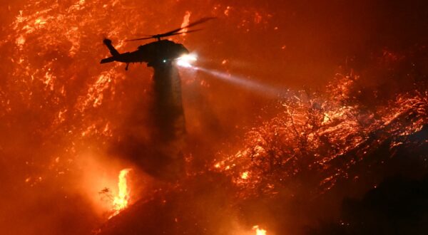 A fire fighting helicopter drops water as the Palisades fire grows near the Mandeville Canyon neighborhood and Encino, California, on January 11, 2025. The Palisades Fire, the largest of the Los Angeles fires, spread toward previously untouched neighborhoods January 11, forcing new evacuations and dimming hopes that the disaster was coming under control. Across the city, at least 11 people have died as multiple fires have ripped through residential areas since January 7, razing thousands of homes in destruction that US President Joe Biden likened to a "war scene.",Image: 953064912, License: Rights-managed, Restrictions: , Model Release: no, Credit line: Patrick T. Fallon / AFP / Profimedia