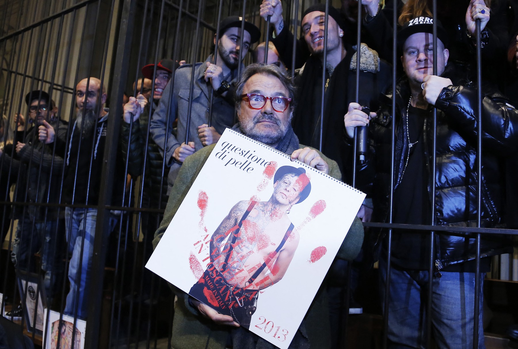 (FILES) Italian Photographer Oliviero Toscani holds his new 2013 calendar dedicated to tattooed people as he poses with his models on January 10, 2013 in Florence. The calendar was designed for the Consortium Vera Pelle by Toscani, known for his advertising campains for Benetton.   Oliviero Toscani, the Italian fashion photographer known for his work on Benetton's provocative advertising campaigns, died on January 13, 2025 aged 82, his family announced.,Image: 953262489, License: Rights-managed, Restrictions: DIGITAL CAMERA, Model Release: no, Credit line: FABIO MUZZI / AFP / Profimedia