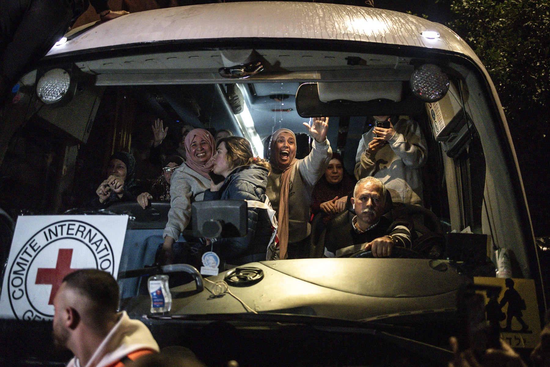 Palestinian freed prisoners wave to the crowd from a Red Cross bus that drove them out of the Israeli Ofer military prison in the occupied West Bank, as they arrive in Beitunia, on the outskirts of Ramallah, in the early hours of January 20, 2025. Crowds cheered, chanted and honked car horns as two buses carrying some 90 Palestinian prisoners freed from an Israeli jail as part of the Gaza ceasefire deal that began on January 19 and saw three Israeli hostages freed by Hamas in the Gaza Strip.,Image: 955502244, License: Rights-managed, Restrictions: , Model Release: no, Credit line: JOHN WESSELS / AFP / Profimedia